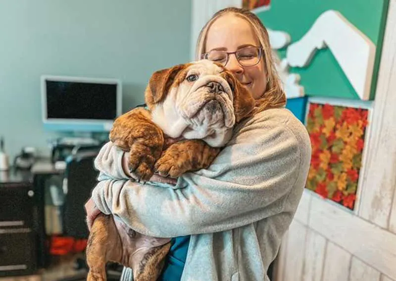 Fur Family team member sharing a warm moment with a dog at the clinic