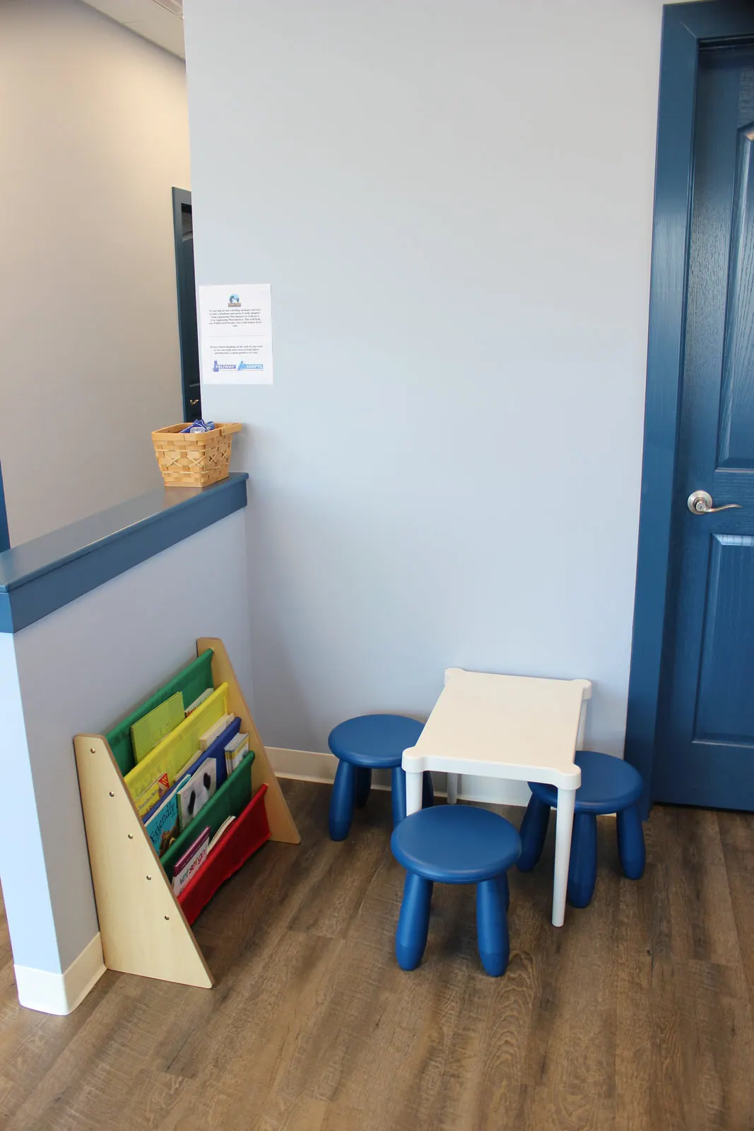 Kids corner with small table, blue stools, and bookshelf of children's books